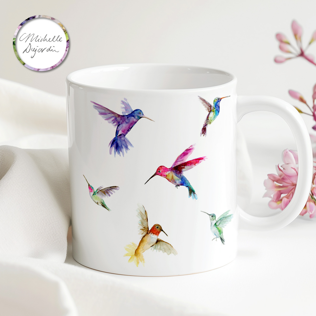 Joyful gift mug with flying hummingbirds in bright colors, painted by Michelle Dujardin
