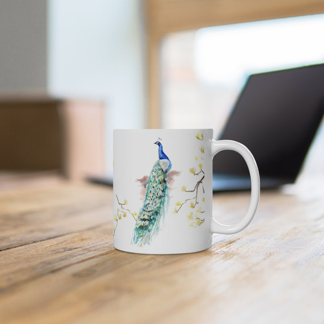 White mug with peacock design on a wooden desk