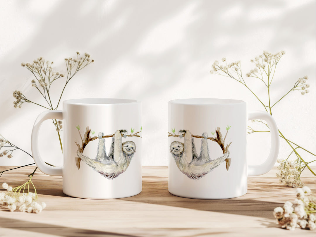 Twee mokken met luiaard afbeelding van Michelle Dujardin op tafel met decoratie