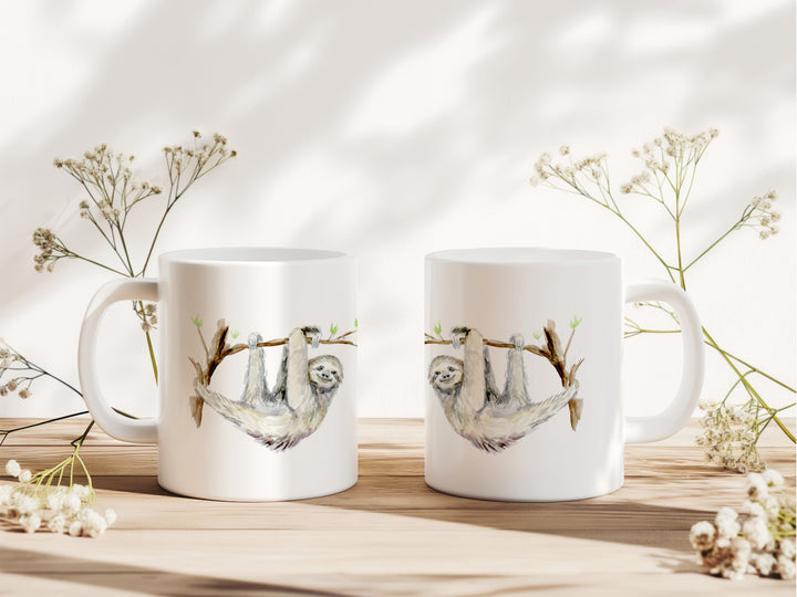 Twee mokken met luiaard afbeelding van Michelle Dujardin op tafel met decoratie