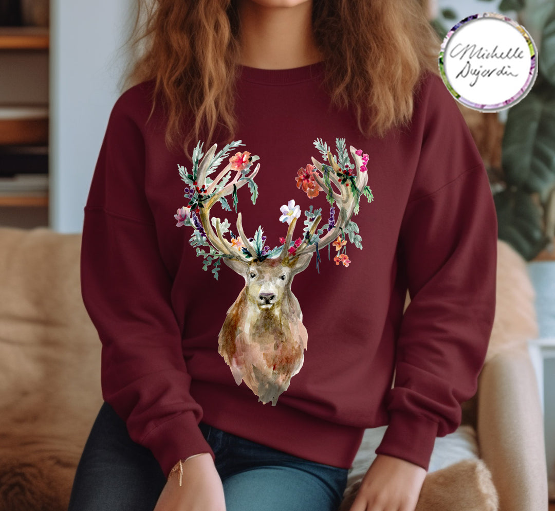 Person wearing a maroon sweatshirt with a deer design, sitting on a couch.