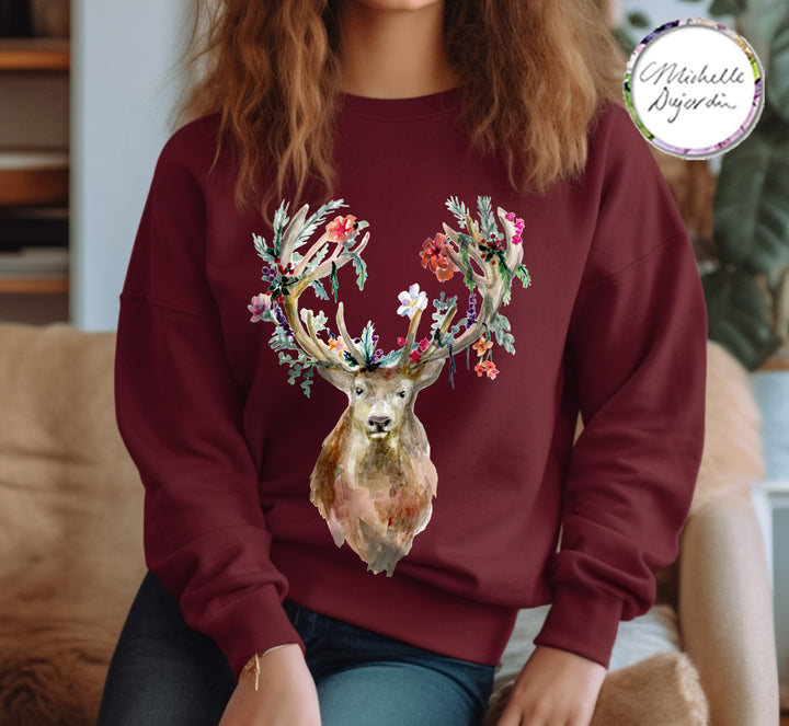 Person wearing a maroon sweatshirt with a deer design, sitting on a couch.