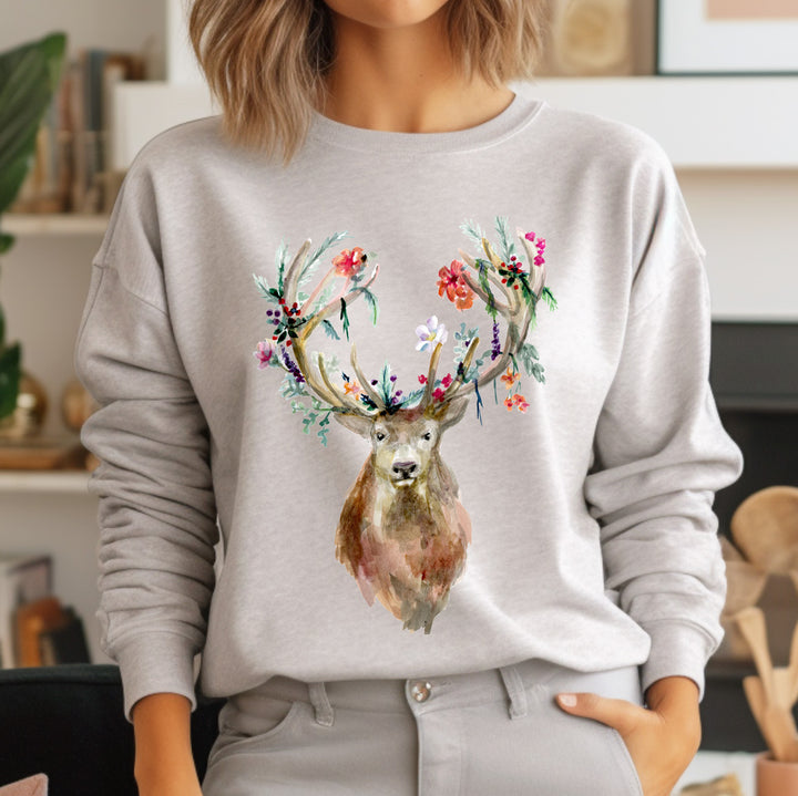 Person wearing a gray sweatshirt with a deer design featuring floral antlers.