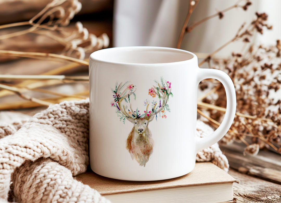 Witte mok met hert illustratie en herfstdecoratie op tafel