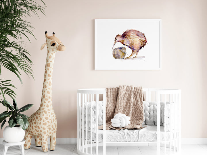 Nursery room with a crib, stuffed giraffe, and wall art of a mother kiwi bird and child.