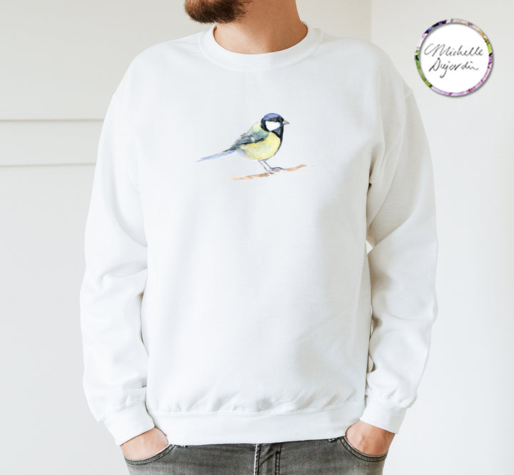 Persoon draagt witte trui met koolmees illustratie op de borst