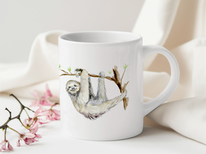 Witte mok met luiaard illustratie en bloemen op tafel