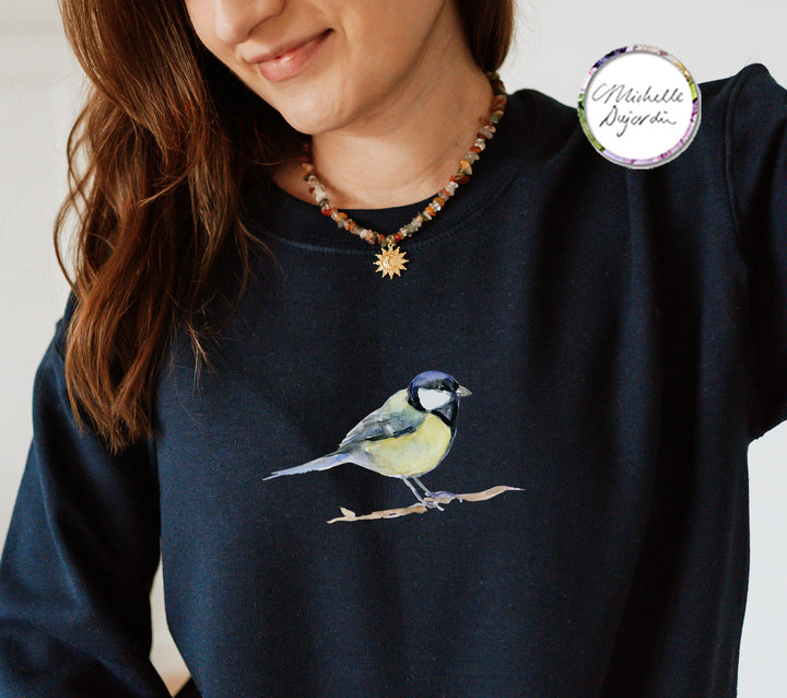 Persoon draagt donkerblauwe trui met koolmees  print