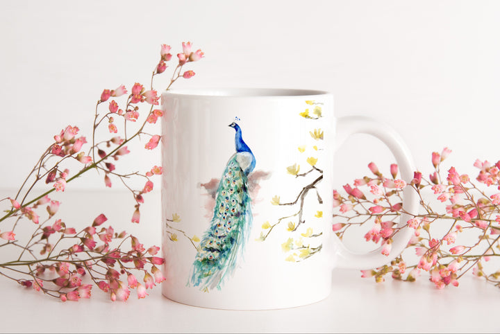Mug with peacock design surrounded by pink flowers on a white background