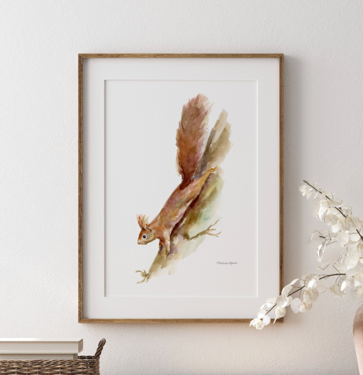 Framed artwork of a squirrel on a white wall with decorative branches.