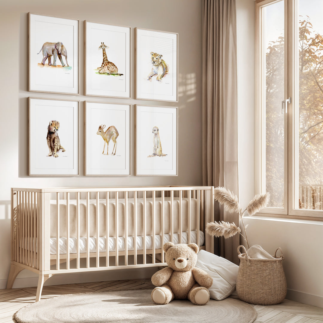 Nursery room with a crib, teddy bear, and framed animal prints on the wall.