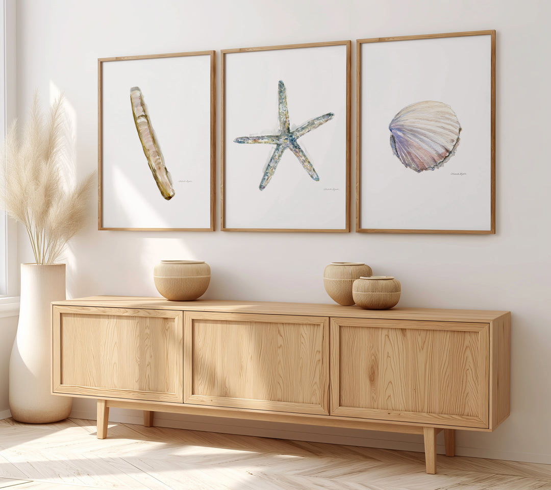 Wooden sideboard with decorative items and framed sealife artwork on a wall.