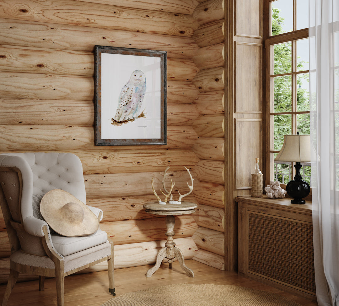 Wooden interior with a chair, table, and framed picture of an snow owl.