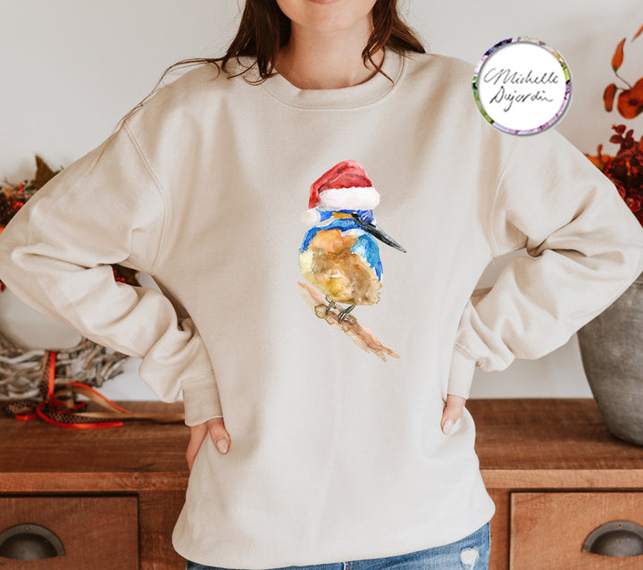 Vrouw draagt zandkleurige trui met ijsvogel kerstprint op de borst