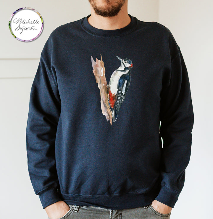 Person wearing a navy blue sweatshirt with a woodpecker design on a plain background