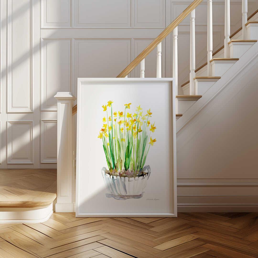 Framed artwork of yellow daffodil flowers on a wall in a home setting