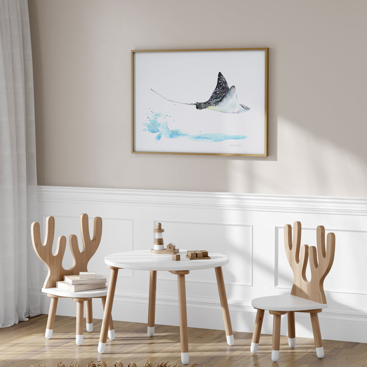 Children's table and chairs with a framed artwork on the wall in a room.