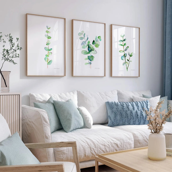 Living room with a white sofa, decorative pillows, and framed botanical art on the wall.