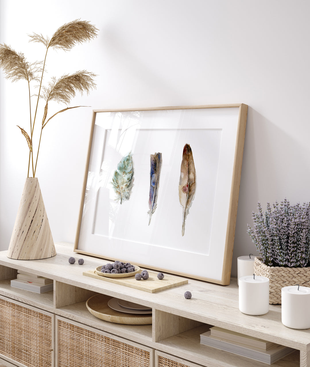 Framed artwork of natural colored feathers on a wooden console table with decorative items.