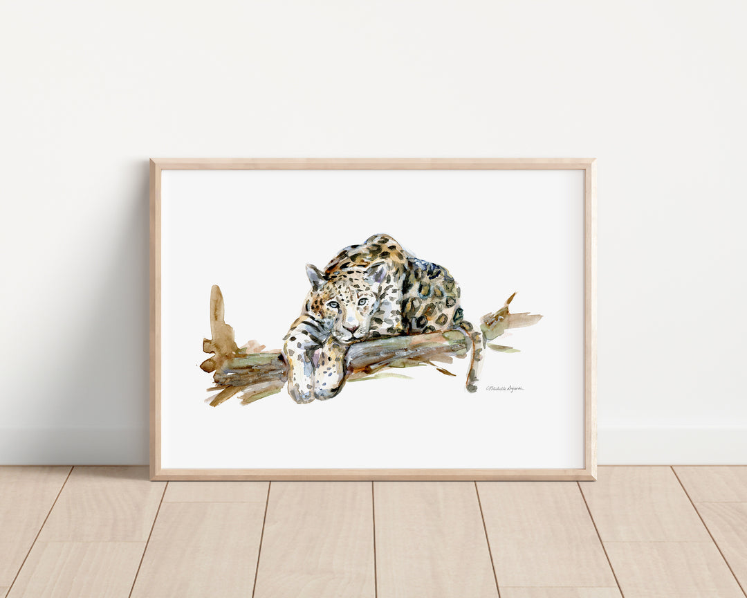 Framed artwork of a leopard on a branch against a white wall.