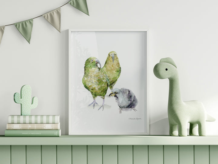 Framed artwork of two green Kea birds on a shelf with decorative items.