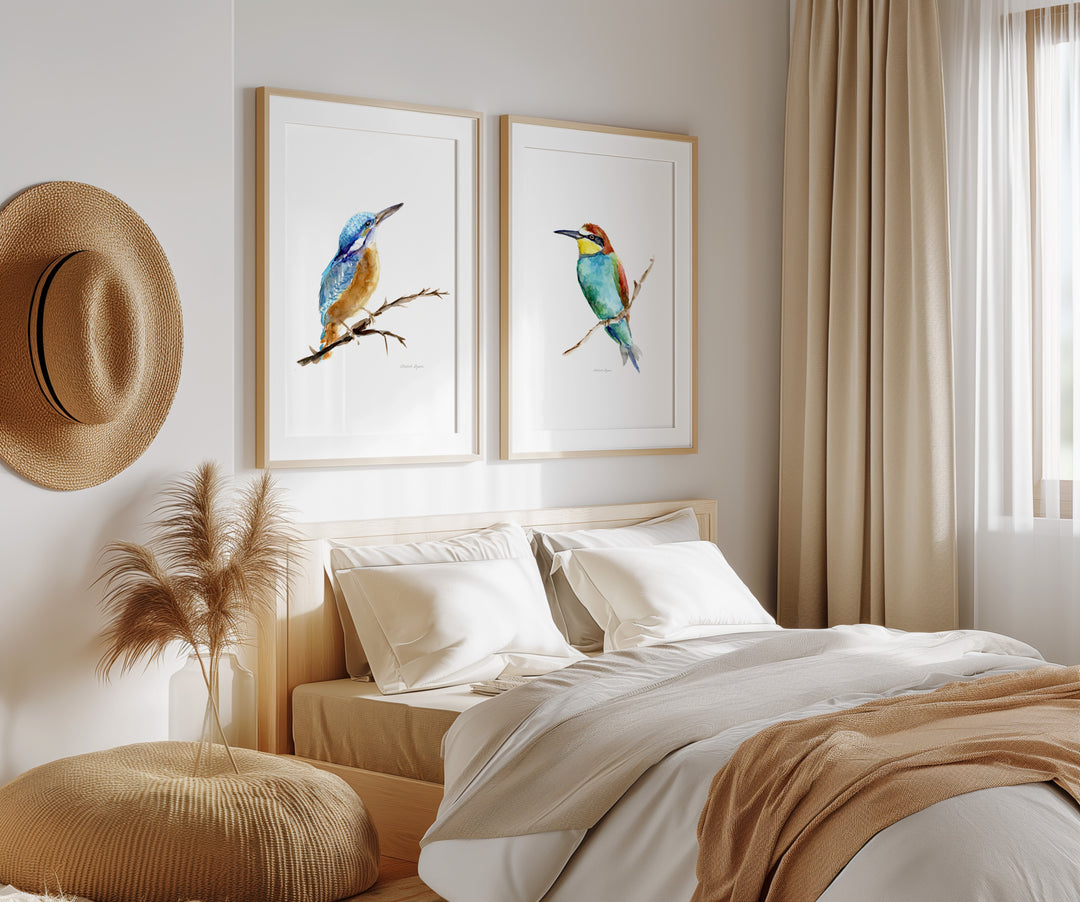 Neatly made bed with decorative pillows, a hat on the wall, and framed bird art in a bedroom.