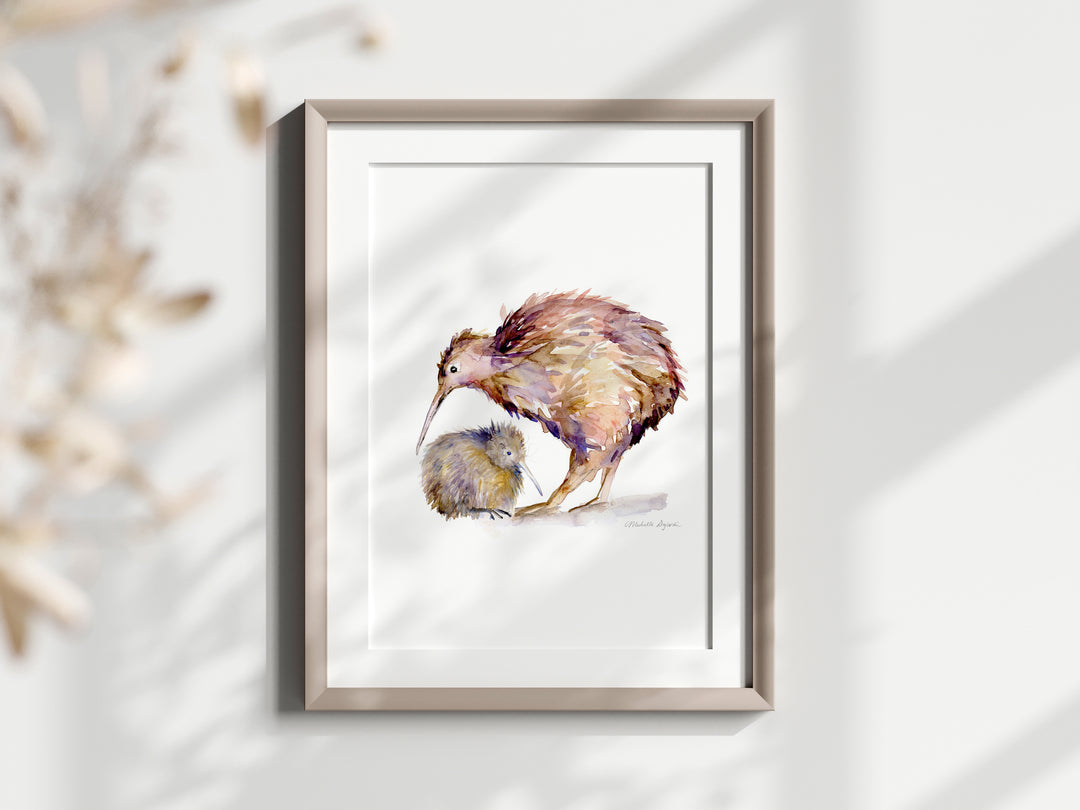 Framed artwork of a kiwi bird and kiwi chick on a white wall.