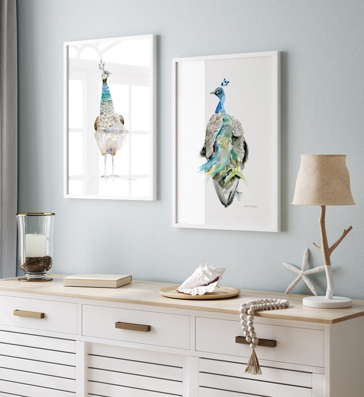 Twee ingelijste pauwen boven wit houten kastje