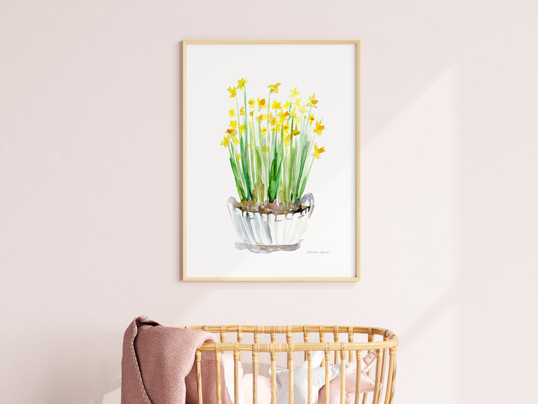 Framed artwork of a potted plant with yellow flowers on a light pink wall.