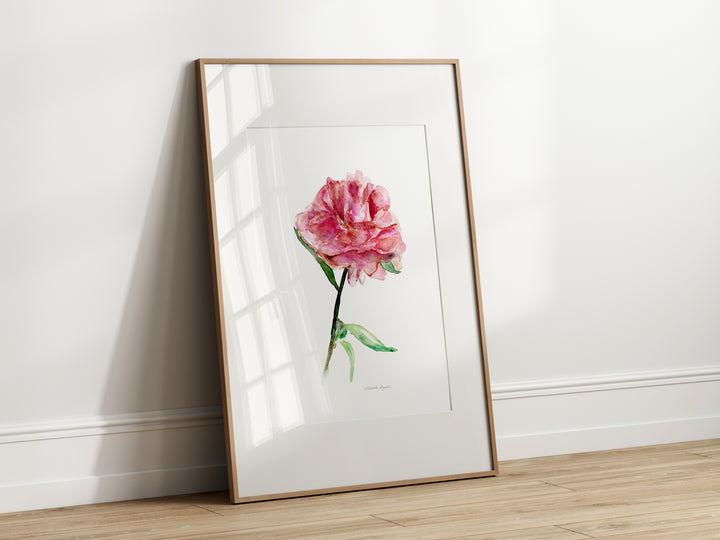 ingelijste print van een pioenroos tegen de muur