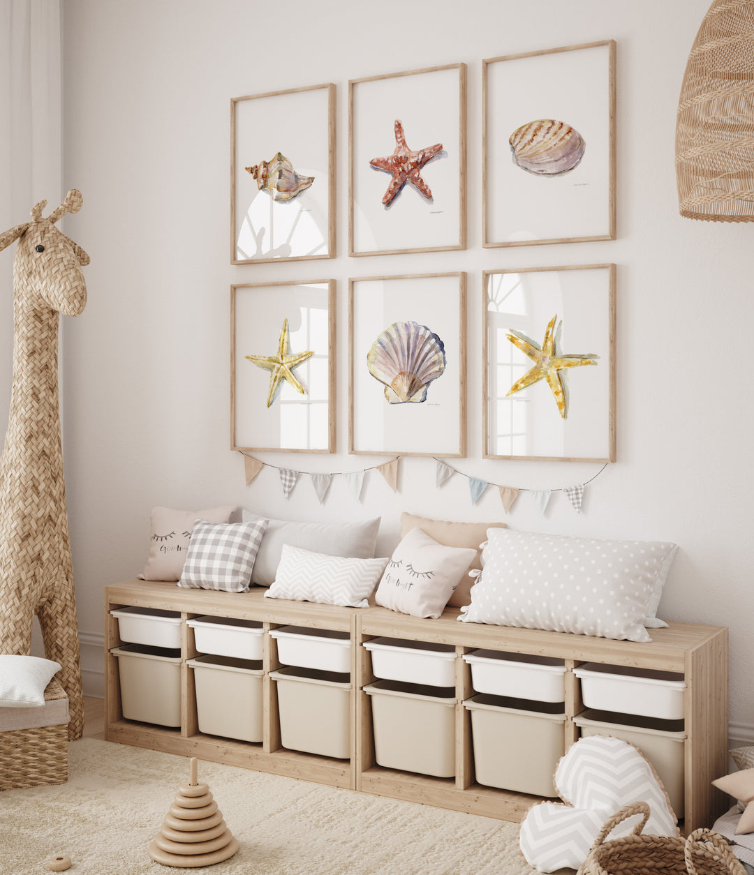 Children's room with wooden storage unit, decorative pillows, and framed pictures of sea stars and shells.