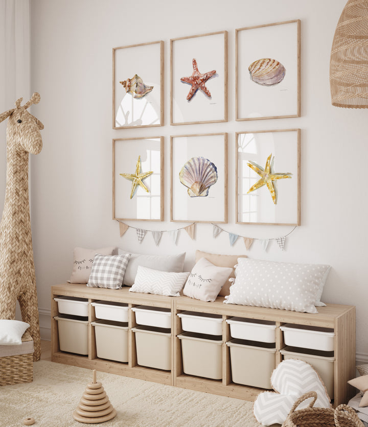 Children's room with wooden storage unit, decorative pillows, and framed pictures of sea stars and shells.