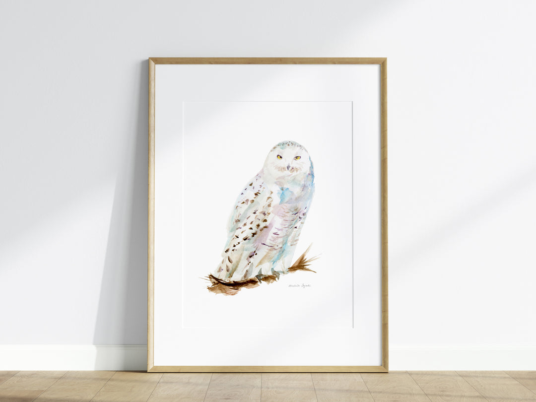 Framed artwork of a snowy owl on a white wall.