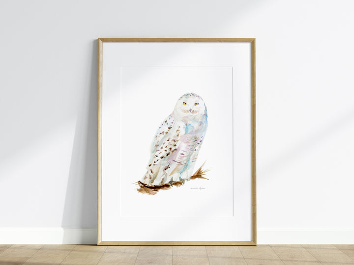 Framed artwork of a snowy owl on a white wall.