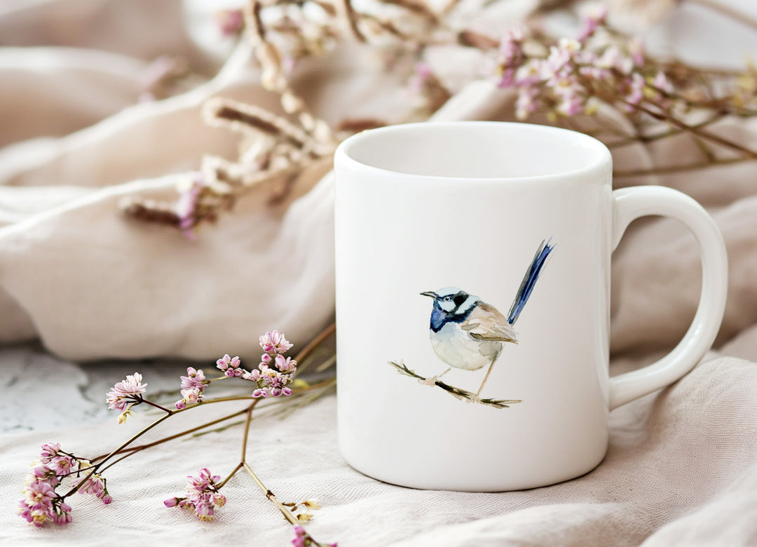 White mug with a bird design on a soft fabric background with flowers