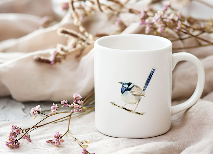 White mug with a bird design on a soft fabric background with flowers