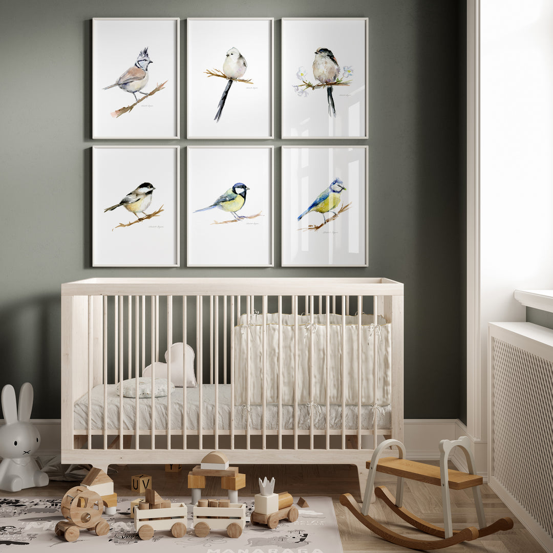 Nursery room with white crib, toys, and wall art of tit birds.